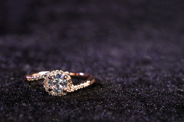 Engagement ring on purple background with copy space. Golden ring.