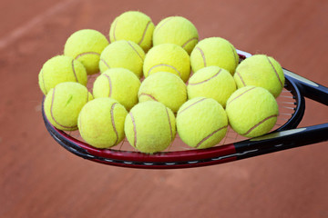 tennis racket and balls on the clay court