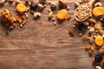 Different nuts and dried fruits on wooden background