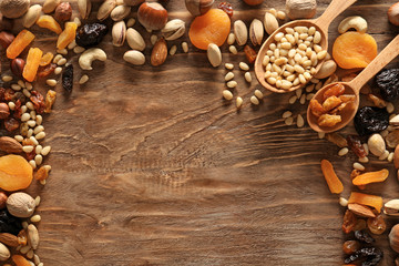 Different nuts and dried fruits on wooden background