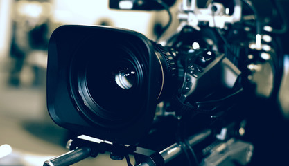 Fototapeta na wymiar Modern video camera with microphone on blurred background