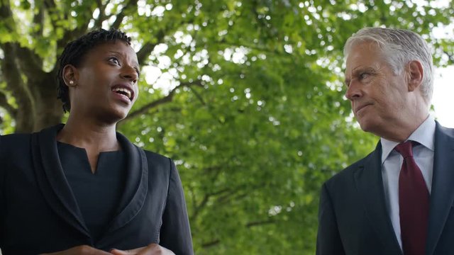 Male reporter interviewing a female councillor as they walk and talk