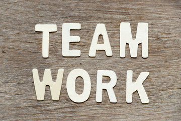 Alphabet letter in word teamwork on wood background