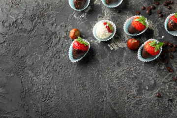 Delicious strawberries covered with chocolate on grey textured background