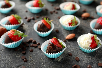 Delicious strawberries covered with chocolate on grey textured background