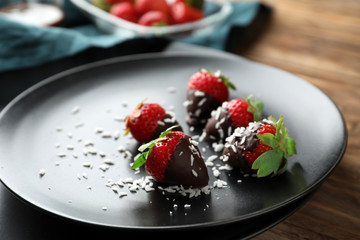 Fresh ripe strawberries covered with chocolate on plate