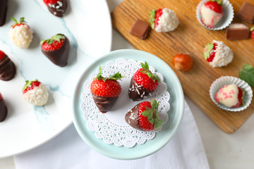 Dessert stand with delicious strawberries dipped in dark chocolate on light table
