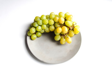 Fresh grape fruit covered with frost dew on grey concrete plate isolated on white background