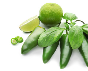 Tasty jalapeno chili peppers with lime and fresh basil on white background