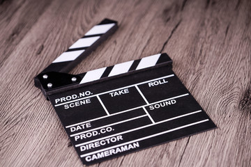 holding clapper board or slate film concept On wooden table.