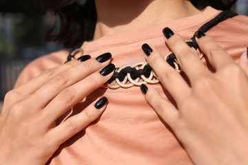 Fashionable young woman with black manicure outdoors, closeup