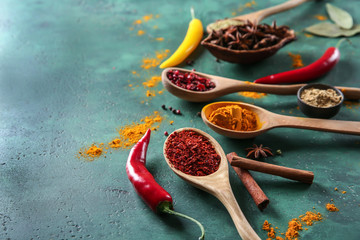 Composition with different dry spices on green background