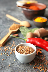 Bowl with flax seeds on grunge background