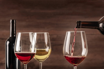 Red wine poured into glass from bottle with copy space