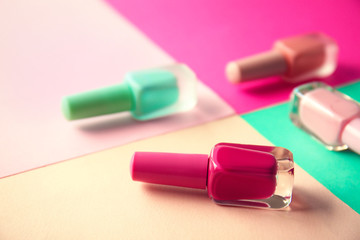 Bottles of nail polishes on color background