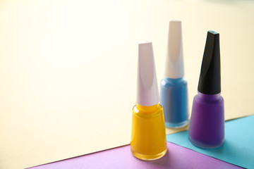 Bottles of nail polishes on color background