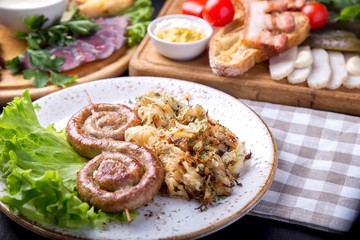 Tasty round roast sausages on wooden skewers with fried sauerkraut. Copyspace