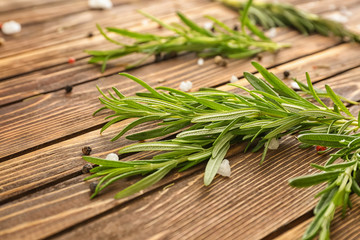 Fresh rosemary and spices on wooden background