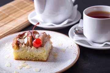 Tasty apple pie on a plate served with cup of tea. Sweet bakery with tea