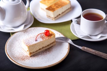Cheesecake served with cup of tea. Tasty sweet dessert on a plate. Cheesecake