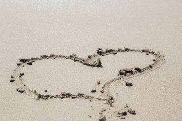 Love sign writing on sand. Heart on a sand