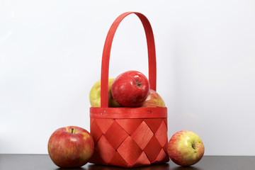 Autumn harvest of apples. Apples in a wicker from a vine basket. On a white background.
