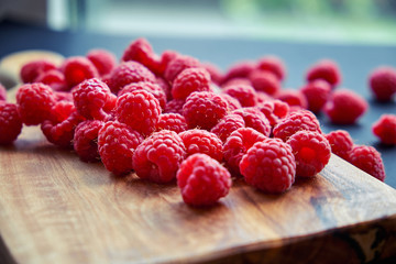Fresh organic raspberries on black background. berries on a wooden spoon
