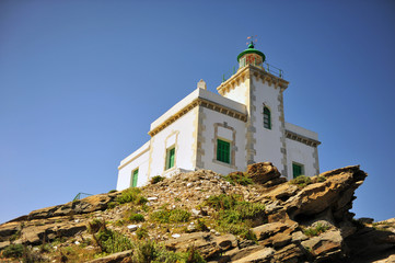 Fototapeta na wymiar Beautiful white stone lighthouse on the rock