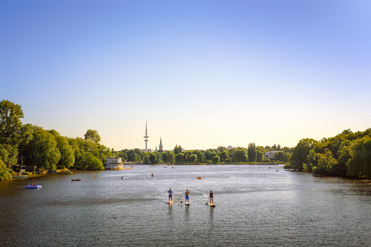 Alster Lake in Hamburg with people paddleboarding and the TV tower in the background