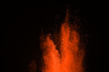 Abstract orange dust explosion on black background. abstract orange powder splatted on black...