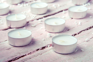 Fototapeta na wymiar A few flat white candles on a beautiful wooden table