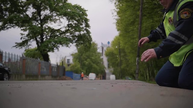 Traffic police worker middle age caucasian man in wet clothes green reflection vest beaten and dirty walking through city park and trips over road on summer day