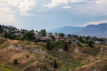 Fototapeta premium Aerial view of homes on top of a hill during a cloudy summer day. Located in Kamloops City, Interior BC, Canada.