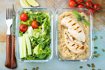 Healthy meal prep containers with quinoa, chicken breast and green salad overhead shot. Top view. Flat lay