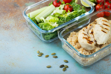 Healthy meal prep containers with quinoa, chicken breast and green salad overhead shot with copy space