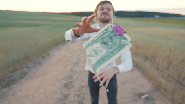 A man chases after a dollar that flies in the wind. the concept of the desire for profit and income