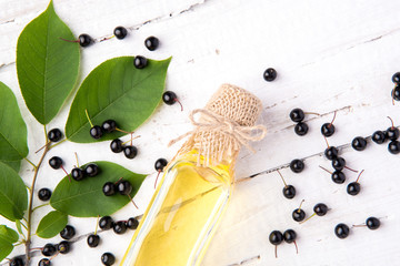Healthy and rich in vitamins oil of berry bird-cherry on a wooden background