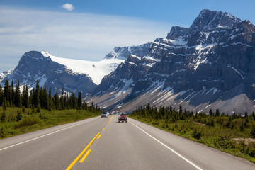 Scenic road in the Canadian Rockies during a vibrant sunny summer day. Taken in Icefields Parkway, Banff National Park, Alberta, Canada.