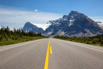 Fototapeta premium Scenic road in the Canadian Rockies during a vibrant sunny summer day. Taken in Icefields Parkway, Banff National Park, Alberta, Canada.