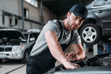 Fototapeta na wymiar professional auto mechanic working with car in repair shop