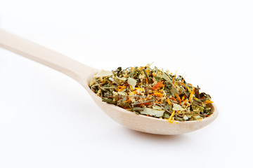 Medicinal herbal tea leafs in a wooden spoon on white background. Health and beauty concept.