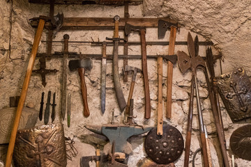 Wallpaper background of ancient medieval weapons hanged on a vintage stone and concrete wall....