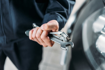 cropped view of workman holding tools and wrenches in hand