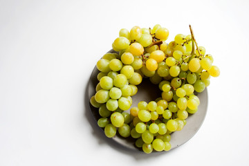 Ripe white seedless grape on grey concrete plate from a high angle view with copy space
