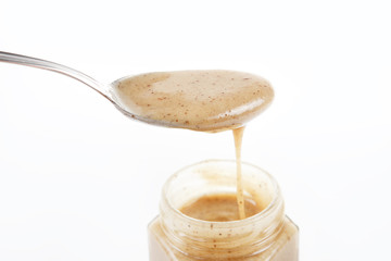 Jar of sweet honey with silver spoon on a white background. Health and beauty concept.