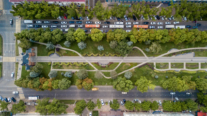 Aerial Drone Flight top down View of freeway busy city rush hour heavy traffic jam highway.  Aerial view of the vehicular intersection,  traffic at peak hour with cars on the road, fly under trees.