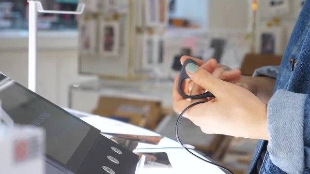 Female Customer Choosing Wireless Earphones In Store