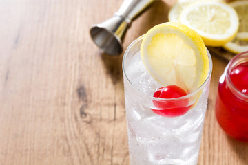 Classic Tom Collins cocktail on wooden table. Copyspace