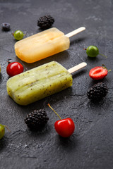 Photo of frozen juice on stick, blackberry,cherry, gooseberries