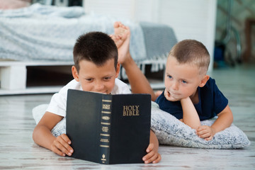 children read a bible on the bed